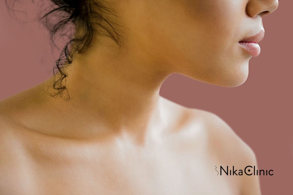 Primo piano del collo e delle spalle di una persona con i capelli ricci, su uno sfondo marrone: è come trovare le risposte nelle Domande Più Frequenti.